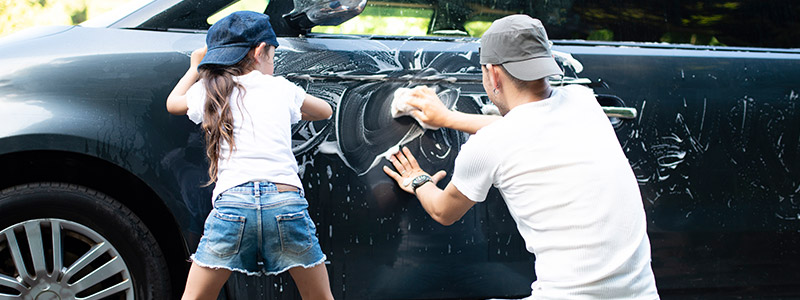 Father and daughter wash the car