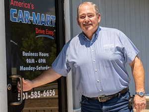 Ted Taylor, Director of Expansion at Car-Mart, opening the door of a dealership