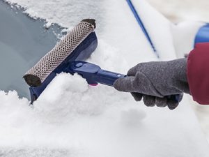 cleaning snow off the windshield
