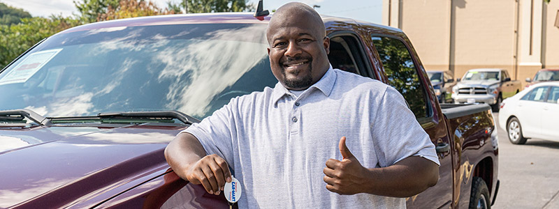 Peace of Mind, man standing if front of truck giving a thumbs up and holding car keys