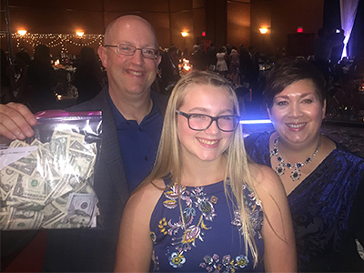 Barry Bagget with his wife and daughter. Barry is holding the cash that was thrown on stage when he walked the cat-walk.