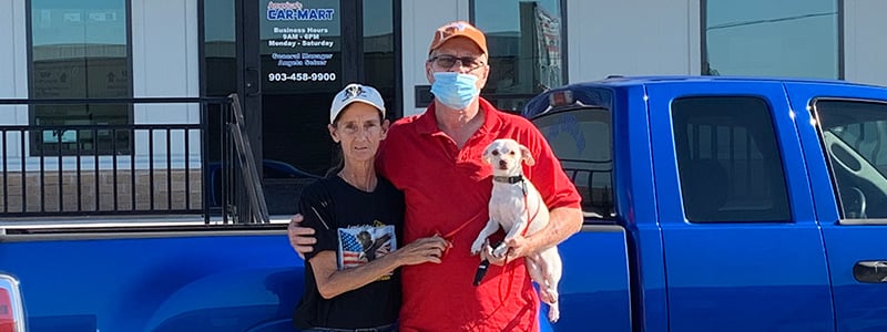 Robert and Karla Cope with their chihuahua, Honey, standing in front of their truck at Car-Mart of Greenville, TX