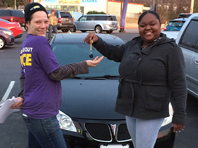 Tiffany Hughes giving the keys to Melissa L. who purchased a new car at Car-Mart of Fort Smith, AR when Tiffany was an Assistant Manager there