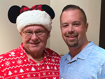 Travis with his dad at a Christmas party