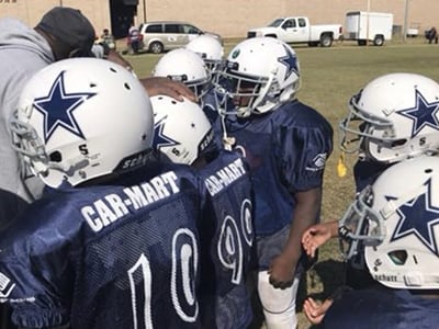 Corey coaching a football team sponsored by Car-Mart of Nacogdoches