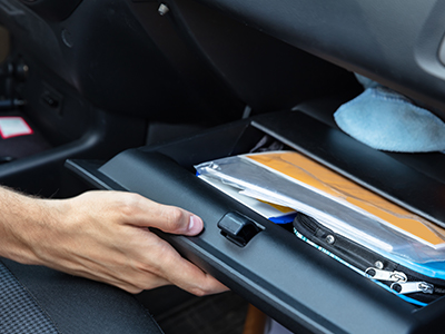 Open car glove compartment with vehicle paperwork inside