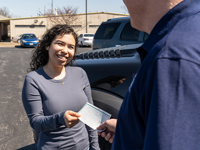 Happy customer receiving a check for her vehicle