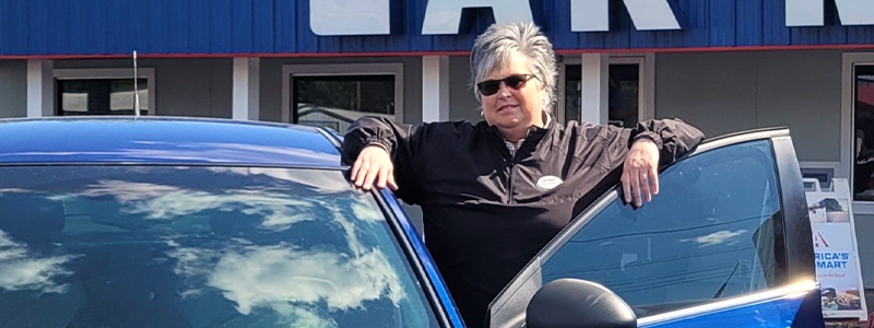 Stacy Barrett, General Manager at Car-Mart of Paducah, KY standing in front of the dealership