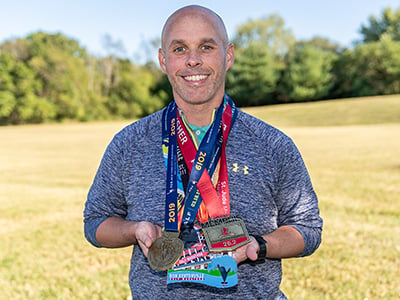 Trey with medals from some of the marathons he ran in