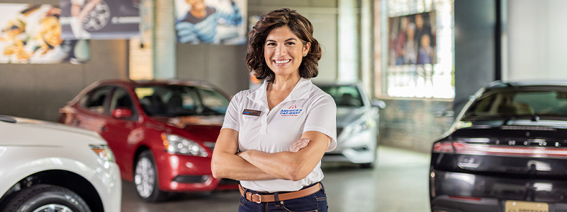 America's Car-Mart spokeswoman standing in front of several cars