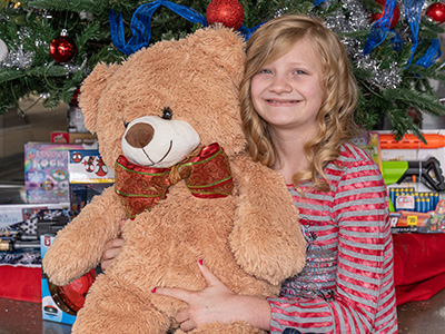 Baylee donates a toy at her local Car-Mart