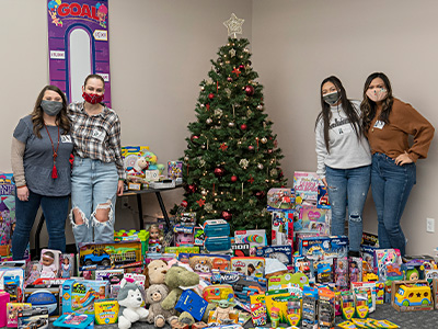 Serve2Perform associates around the tree at Car-Mart's Corporate office with the toys they donated for our Toy Drive in 2020