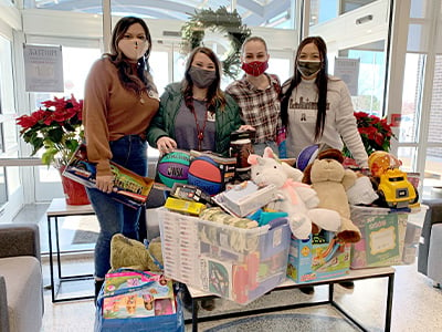 Serve2Perform associates around the tree at Car-Mart's Corporate office with the toys they donated for our Toy Drive in 2020