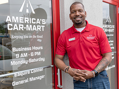 Esquire Conner, General Manager at America’s Car-Mart of Springfield South, MO, standing by his dealerships front door