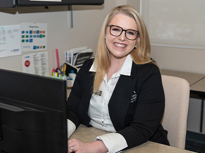 Amy Stephan, Account Resolution Manager, sitting at her desk at the corporate office