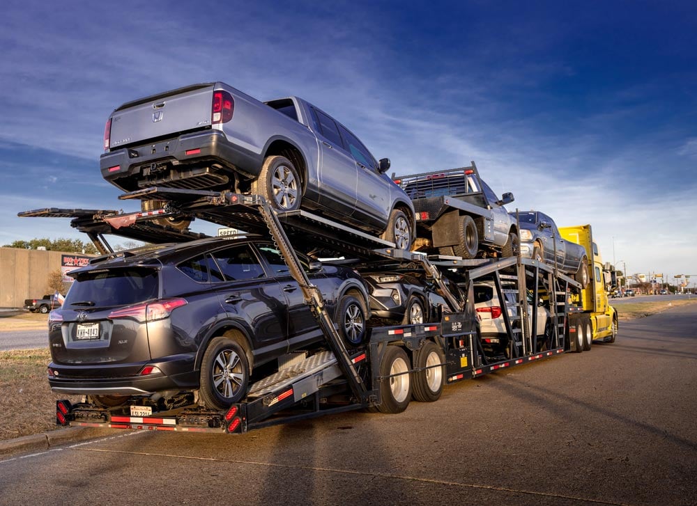 Large truck hauling cars for delivery to Car-Mart
