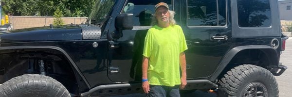 Car-Mart customer, Doug Childress, standing by his Jeep