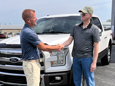 General Manager of Rogers Curtis Valentine shaking hands with customer James Holland