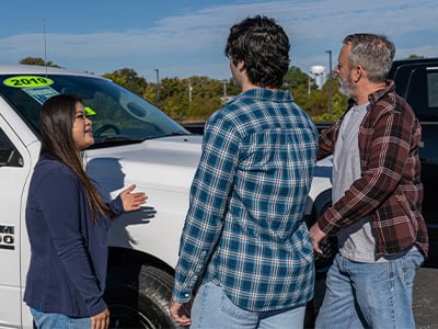 Father and son being shown a vehicle by a sales associate.