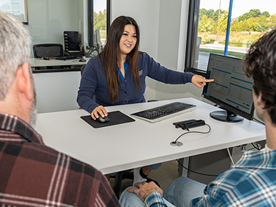 A Car-Mart Sales Associate completing the sale with a Father and son.