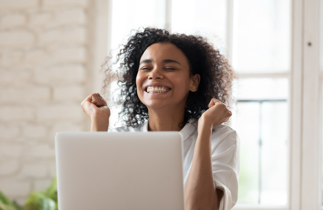 African American female smiling sitting at laptop computer