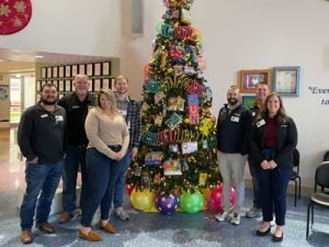 America's Car-Mart Associates Standing by Christmas Tree and Delivering Toys to a Children's Hospital during the Company's 15th Annual Holiday Toy Drive.