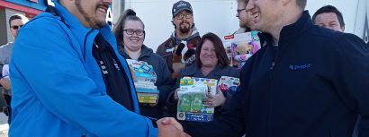 America's Car-Mart General Manager Shaking Hands with Partner at 15th Annual Holiday Toy Drive
