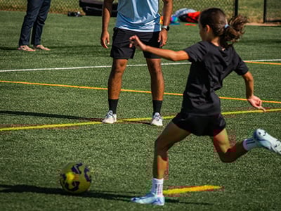 Youth female kicking yellow soccer ball